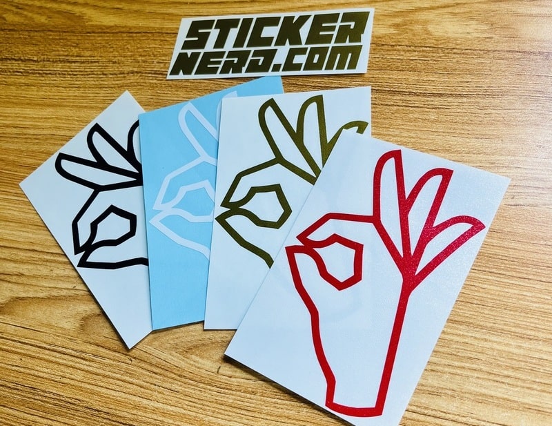 Four vinyl stickers with different designs on a wooden surface, featuring the 'StickerNerd.com' brand.
