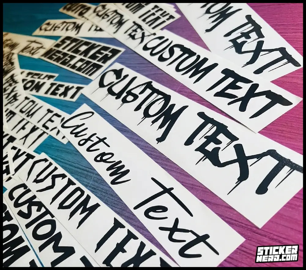 A close-up of multiple white rectangular stickers with black dripping-style text reading 'CUSTOM TEXT' arranged diagonally on a colorful striped background. A small 'Sticker Hero' logo appears in the bottom-right corner.