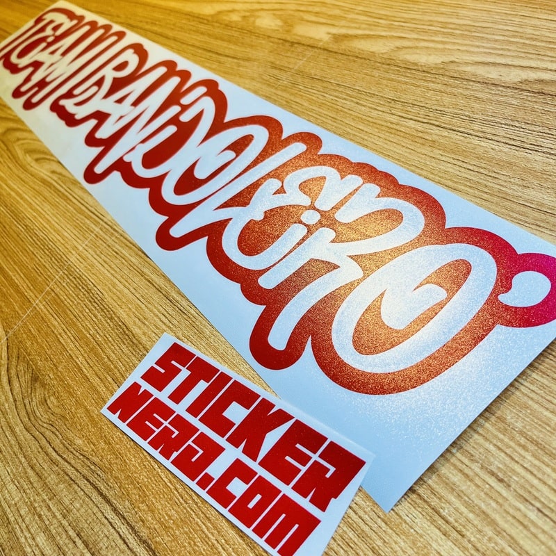 Sticker with red and white text on a wooden surface