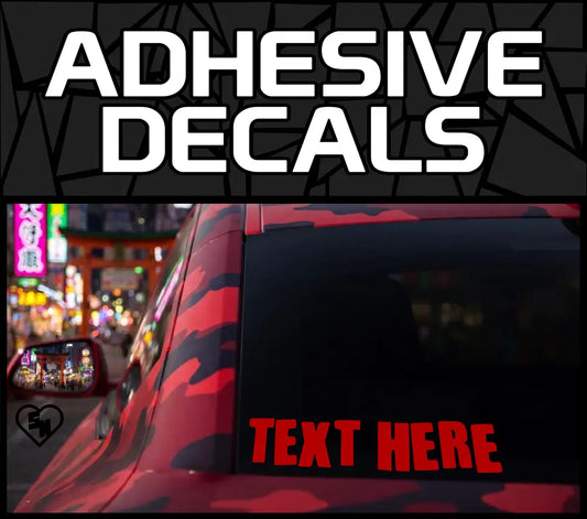 Graphic showing adhesive decals text above a photo of a red and black camouflage-patterned vehicle rear window displaying a bold red text here customizable vinyl layout.