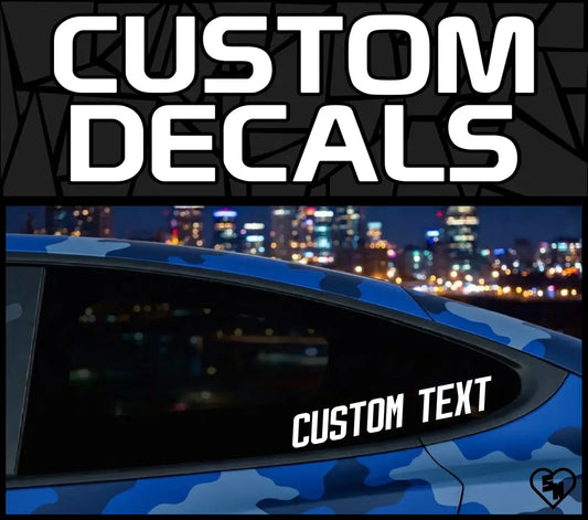 Product showcase graphic for StickerNerd.com titled "CUSTOM DECALS" in bold white font, featuring a sample text decal on a blue camo vehicle window with a blurred city skyline background.